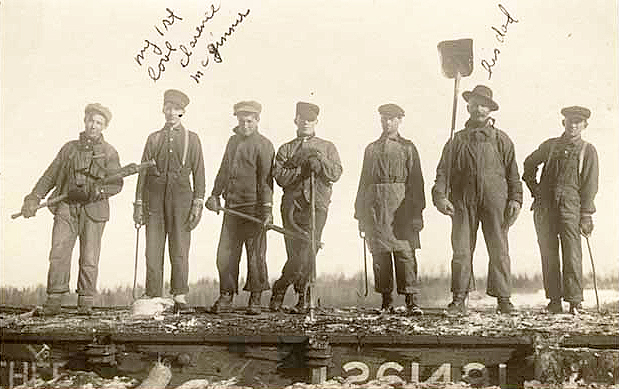 Group of lumberjacks posed atop a railroad car with their peavies and cant hooks, unknown location in the Arrowhead Region, ca. 1910.